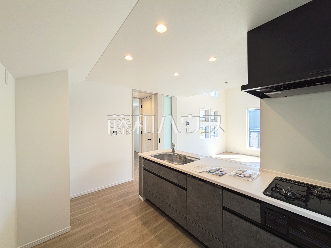 2号棟　キッチン　カウンターを設けた対面キッチンからはリビングの様子が見渡せます。家族の会話と笑顔が生まれるホットスポットで、何気ない光景が光に満ちた幸せのひと時となる事でしょう。【日野市大字日野】／撮影日：2025年10月17日