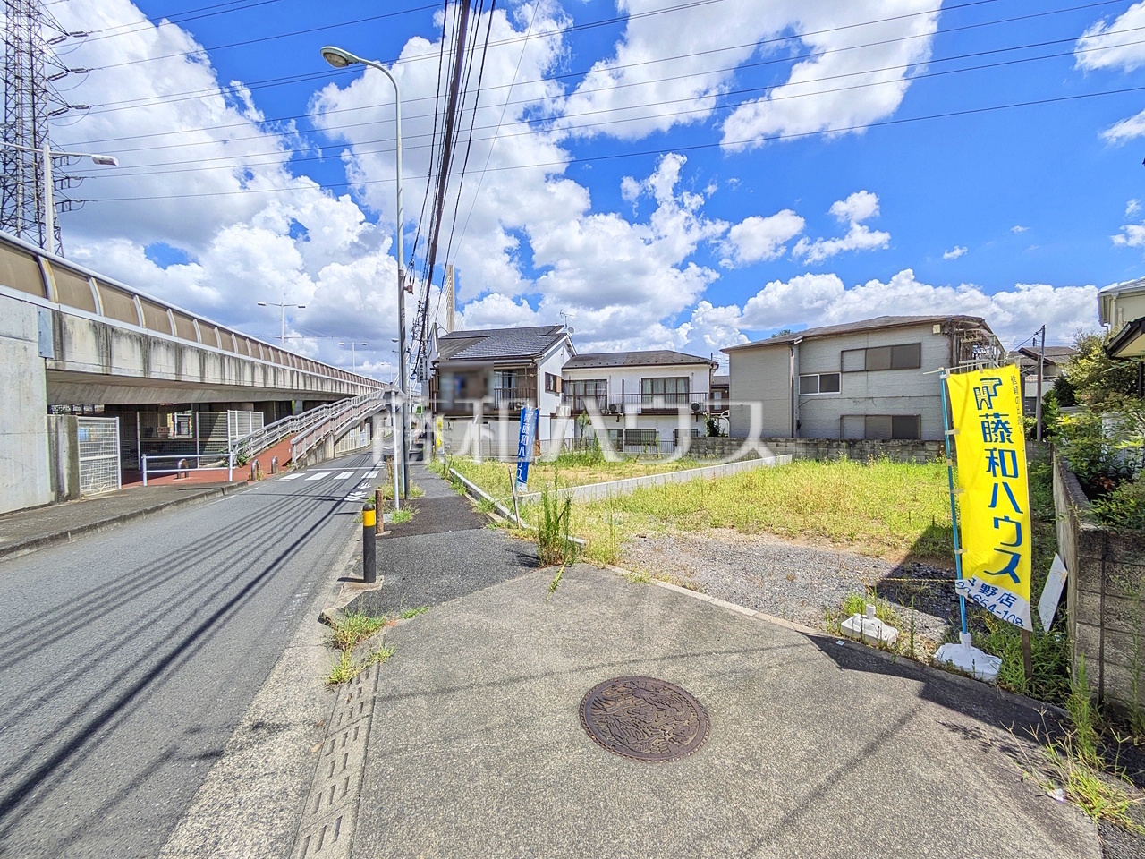 接道状況および現場風景 【日野市百草】
視界いっぱいに広がる青空から、陽光が降り注ぎます。家々をそっと飾るように添えられた植栽が光を浴び、子供たちの成長とともにご家族の幸せを願い育っていくことでしょう/撮影日:2026年8月8日
