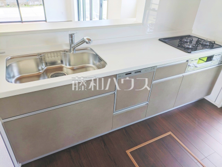 19号棟　キッチン　【昭島市拝島町５丁目】シンクとコンロが一続きになっているシステムキッチンでは横の移動がメインになるため、うっかりお料理をこぼしてしまってもお手入れがしやすいのが魅力です。／撮影日2024/06/22