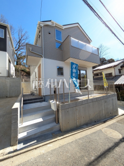 2号棟　外観　【多摩市聖ヶ丘３丁目】白を基調とした明るめの配色で、柔らかくほっこりとした姿のマイホームです。暖かみのある木目も配し、優しい色使いでコントラストを抑え落ち着きある家を演出しています。　／撮影日2025/02/24