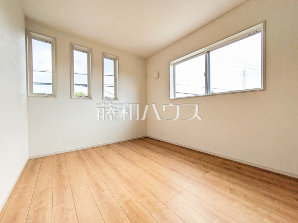 1号棟　居室　【日野市新井１丁目】
３連窓がおしゃれな印象の北東側6帖の洋室になります。窓を開ければ、北側に流れる浅川からのさわやかな風を感じることができます。