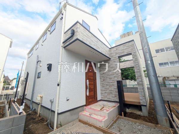 I号棟　外観　【狛江市東野川１丁目】白を基調とした明るめの配色で、柔らかくほっこりとした姿のマイホームです。暖かみのある木目も配し、優しい色使いでコントラストを抑え落ち着きある家を演出しています。　
