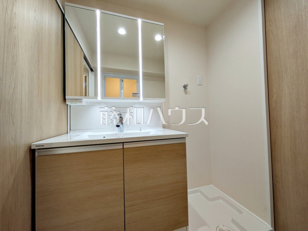 ≪洗面室≫三面鏡付きの洗面台。鏡の裏にも収納があり、歯ブラシや化粧品等もすっきり収納できます。　【日商岩井方南町マンション】