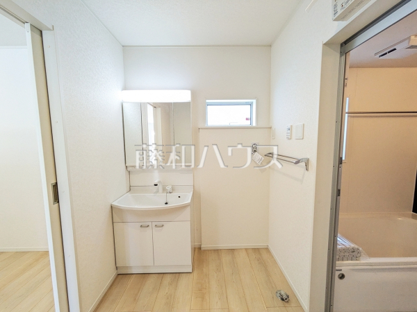 2号棟　洗面室　【糸満市字喜屋武】 三面鏡付きの洗面台。鏡の裏にも収納があり、歯ブラシや化粧品等もすっきり収納できます。 